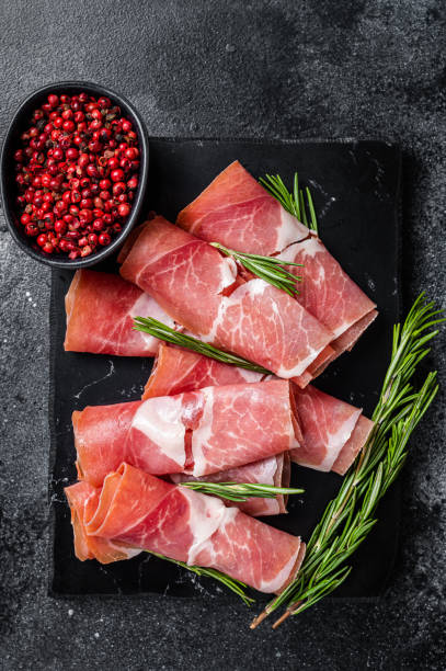 istock Traditional Spanish Jamon Serrano ham on marble board. Black background. Top view 1400488360