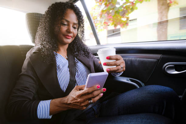 istock Businesswoman using cell phone during private car transport. 1400489974