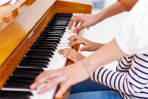 Hands of a child playing the piano