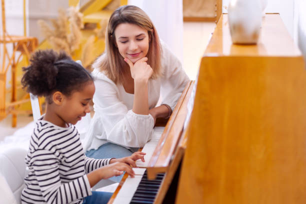 istock Teacher pianist gives piano classes to a young little student 1400493387