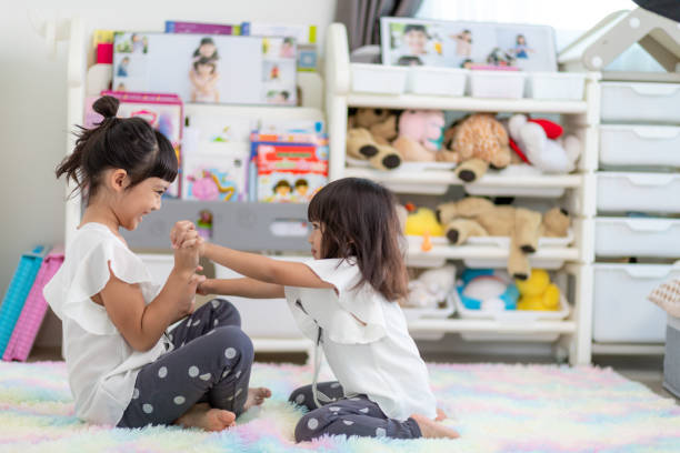 istock Cute little children playing while sitting on carpet at home 1400497685