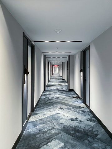 An empty long hotel corridor where thousands residents would walk to and from their rooms.