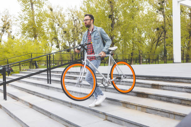 istock Young man carrying a bicycle on stairs 1400502359