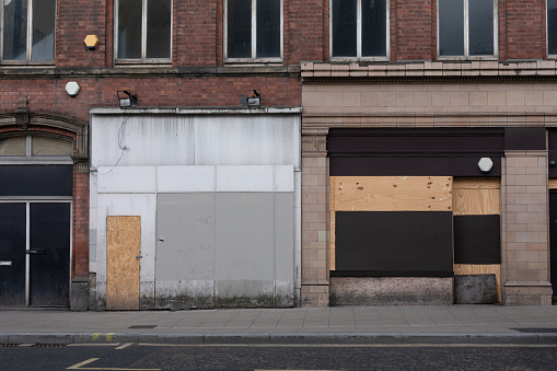 Closed city centre shop front in England due to recession and boarded up