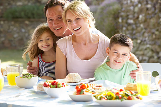 istock Happy family eating bread and vegetables outside 140050927