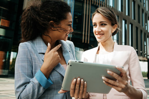 istock Two young businesswomen looking at digital tablet and discussing new project. 1400511336