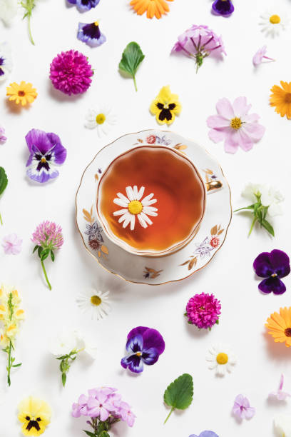 istock Herbal tea in a vintage porcelain mug with spring and summer flowers on white background. Flat lay, bright colorful pattern, top view. Summer country creative concept. 1400512366