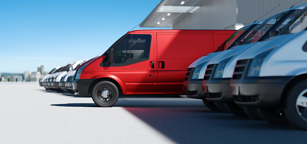 Red delivery vans standing out from a fleet of white vans. Express delivery and shipment service concept. 3d rendering