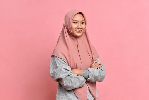 Happy Young Asian Muslim woman smiling on pink background