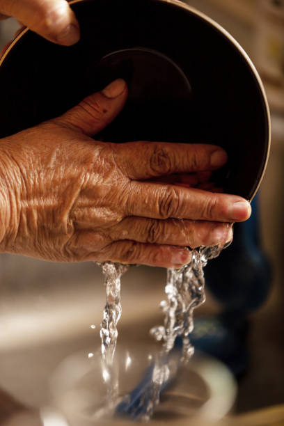 istock Old woman washing the dishes. 1400521514