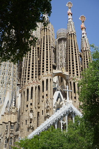Barcelona, Spain - May 23, 2022: The back of the cathedral seen from the adjacent small park. Partly hidden by trees.
