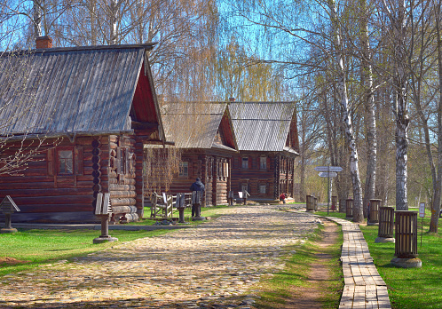 Kostroma, Russia, 05.07.2022. Museum of Russian Wooden Architecture. A street with a pavement along residential buildings (signs \