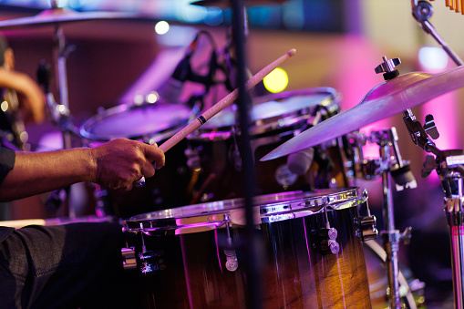 Close up hands of a musician playing drum set in a concert. Motion image.