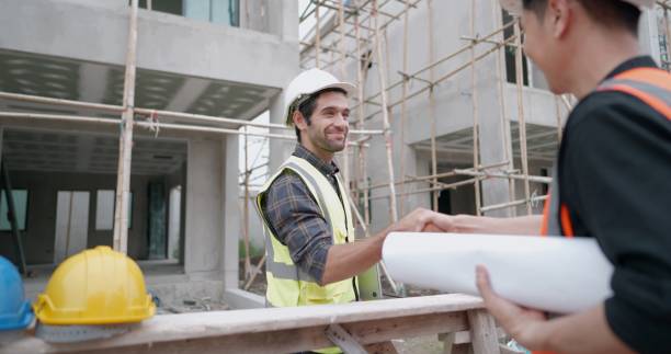 istock Male civil engineer or architect hand shake with contractor after discussing about designing of building styles and inspect progress of housing project at construction sites. Worker work in real estat. 1400530710