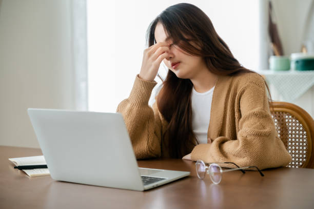 istock Office syndrome. Overworked tired young asian woman feeling headache, having eyesight problem after computer laptop work. Stressed young woman suffering from fatigue at home 1400530985