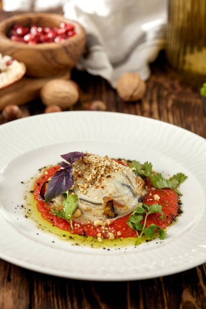 istock Hot appetizer - baked eggplant with cheese and tomatoes. Stuffed eggplants with mozzarella cheese and tomato sauce in rustic style. Eggplant and cheese appetizer on white plate in italian style. 1400531703