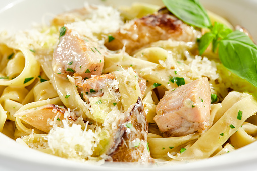 Traditional Italian lunch - pasta fettuccine with chicken and mushrooms with parmesan cheese. Creamy pasta with mushroom and chicken. Chicken and mushroom in cream sauce with homemade pasta