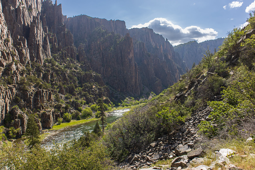 A river flows through Black Canyon of the Gunnison National Park in Colorado in a view from the Gunnison trail on the way to the bottom of the canyon