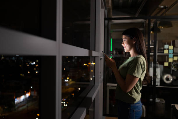 istock Woman working late at a coworking office and using her cell phone 1400537620