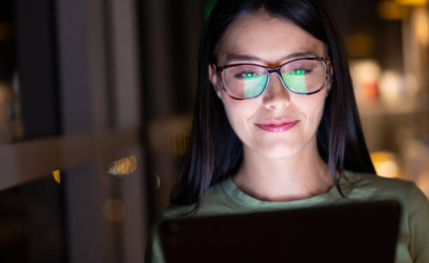 istock Business woman working late and watching graphs on a tablet 1400537626
