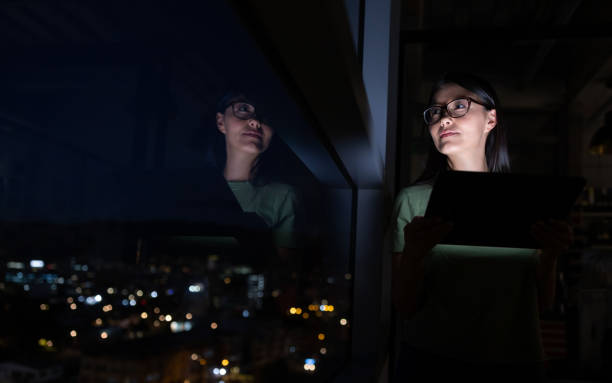 istock Business woman working late at the office using a tablet and looking through the window 1400537643