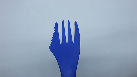 small blue red plastic spoon  fork on a white background