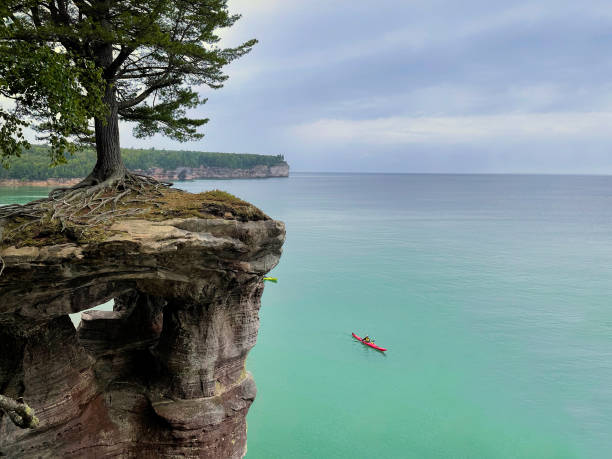 Kayaker on Lake Superior with Chapel Rock above at Pictured Rocks National Lakeshore in Michigan's Upper Peninsula
