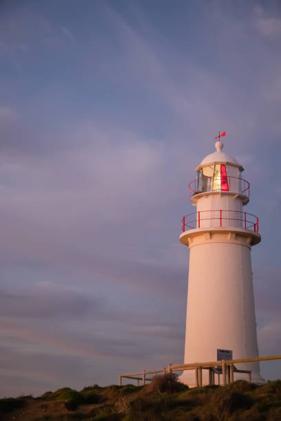 istock White lighthouse with red elements against the backdrop of the dark blue sunset sky, close up 1400549430
