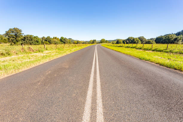 istock Rural country road under sunny clear blue sky 1400550785