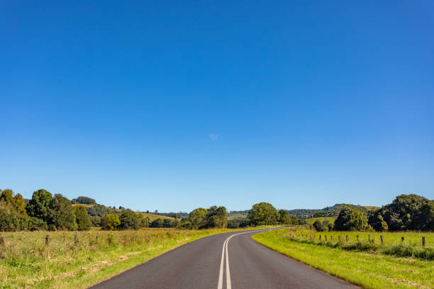 istock Rural country road under sunny clear blue sky 1400550807