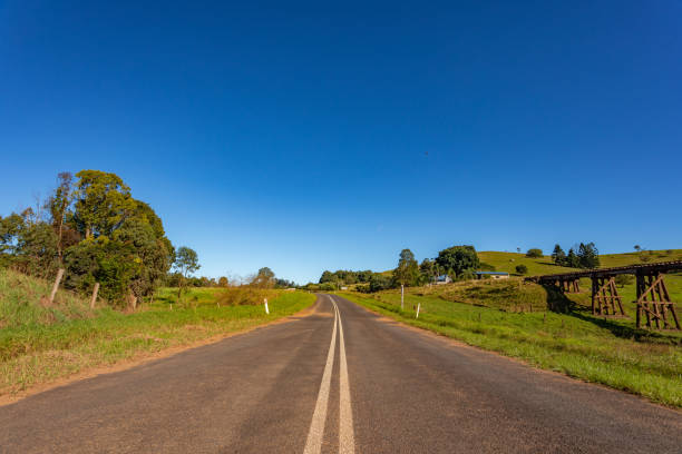 istock Rural country road and railway bridge under sunny clear blue sky 1400550864