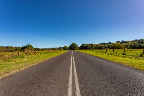 istock Rural country road under sunny clear blue sky 1400550903