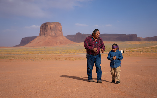 Indigenous navajo Father and son talking while talking in Monument Valley