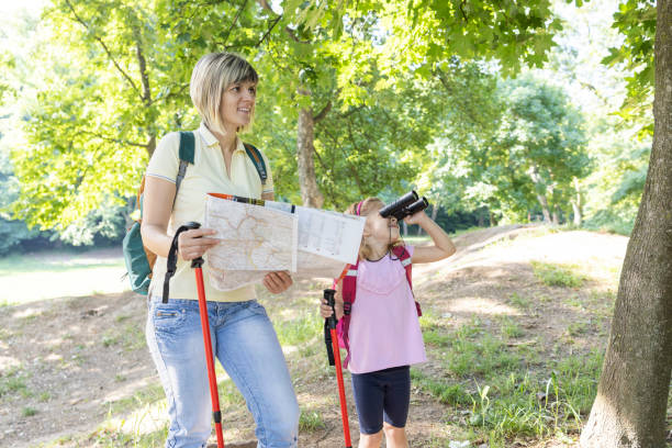 istock Woman with a map standing by daughter using binoculars on a hike 1400552211