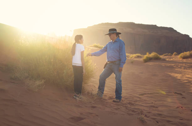 ojciec pokazuje córce rodzimą roślinę w monument valley o zachodzie słońca - north american tribal culture environment child plant zdjęcia i obrazy z banku zdjęć