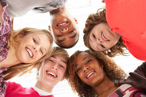 Five Teenage Friends Looking Down Into Camera Five Teenage Friends Looking Down Into Camera Smiling teenagers only stock pictures, royalty-free photos & images