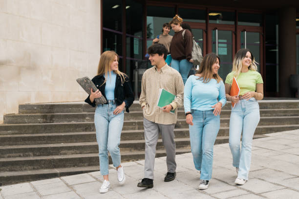 istock Happy young friends walking near university building after studies 1400555003