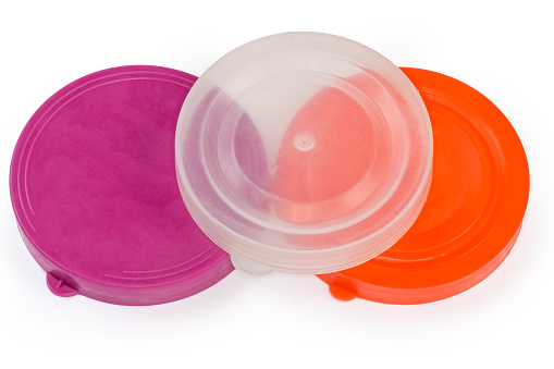Round reusable used colored and clear lids made with elastic plastic for glass jars with wide mouth on a white background