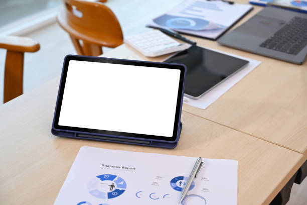 istock Mockup digital tablet, laptop and financial documents on office desk. 1400556710