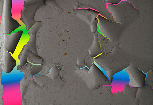 Close-up of paint peeling texture against rainbow background.