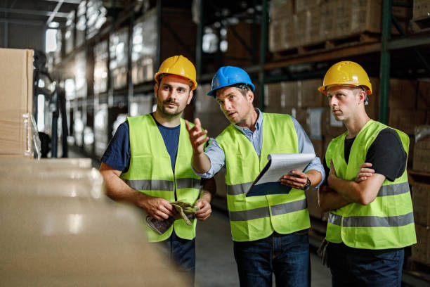 istock Manager giving instructions to his workers in distribution warehouse. 1400561174