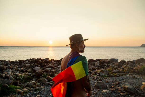 retrato de un hombre de perfil con una bandera del orgullo lgtbi - gay pride flag gay pride gay man homosexual fotografías e imágenes de stock