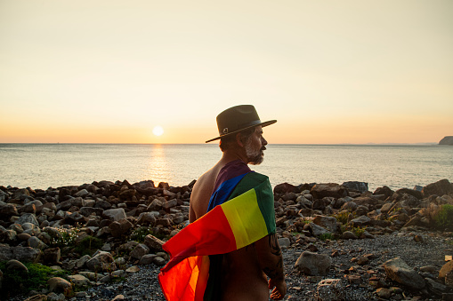 Portrait of a man in profile with an lgtbi pride flag