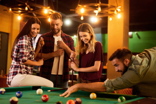istock Group of friends having fun while playing pool in a local pool hall 1400562583