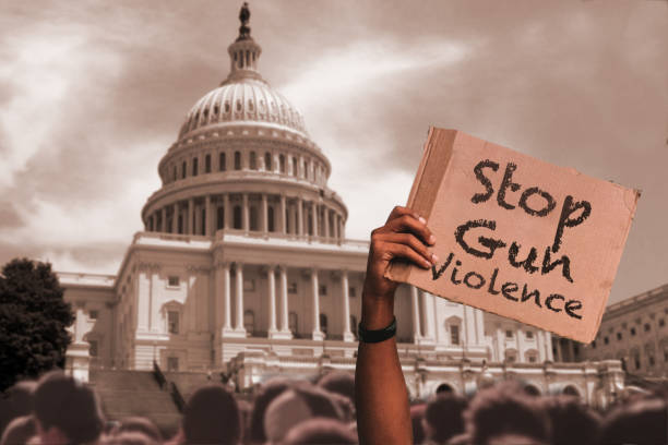 остановите насилие с применением огнестрельного оружия - протестующий держит плакат перед зд�анием capital building - gun control стоковые фото и изображения
