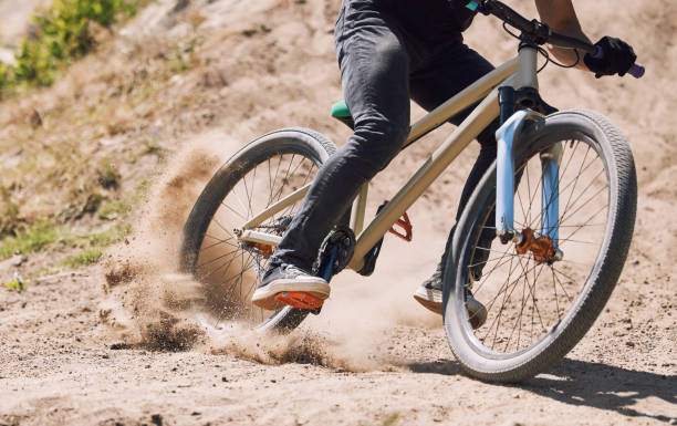 istock Closeup of an unknown cyclist cycling outside in nature. Athlete training and testing his brakes for safety before starting his cardio workout. Unrecognizable male braking while doing extreme sports 1400566765
