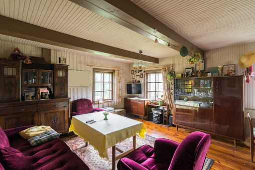 Living room of an old homestead. Vintage furniture, hardwood floor, small windows.