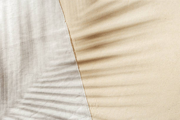 istock Summer background, top view beach towel on sand with  sun shadow from palm leaf. Summer aesthetic photo pale beige colored, copy space, vacation and relaxation concept. Top view sandy beach. 1400568414