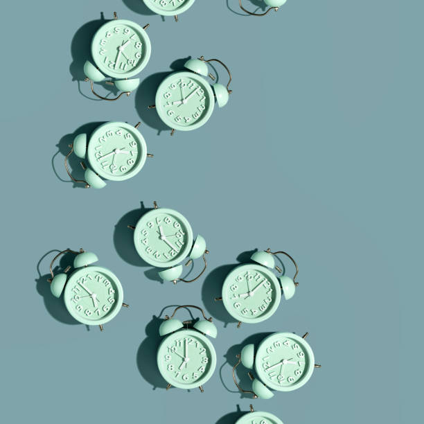 Top view of creative pattern made of red alarm clocks on a blue background stock photo