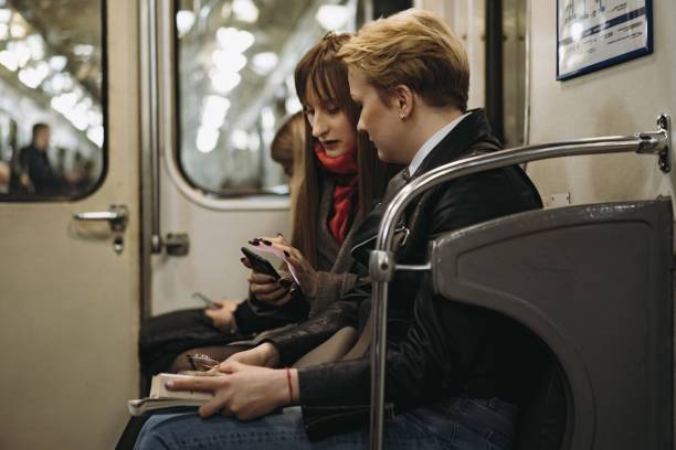 istock young caucasian women sitting in subway carriage looking at smartphone. Image with selective focus, toning and noise effect 1400569430